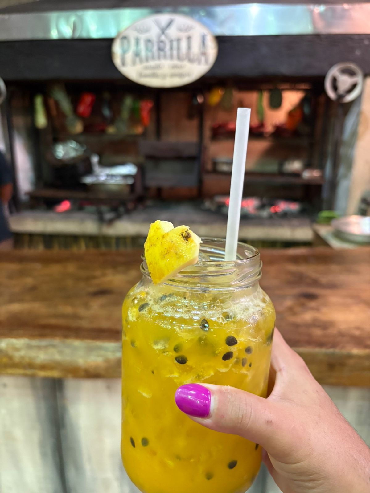 Drink de maracujá em frente à parrilla